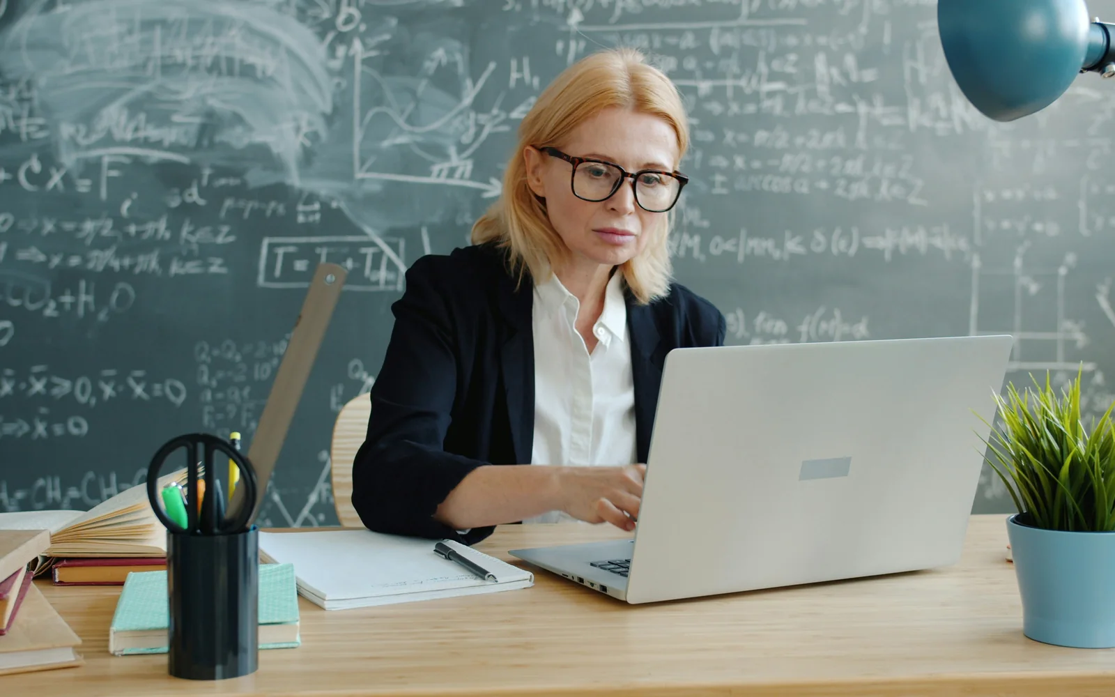 Преподаватель работает за ноутбуком в аудитории